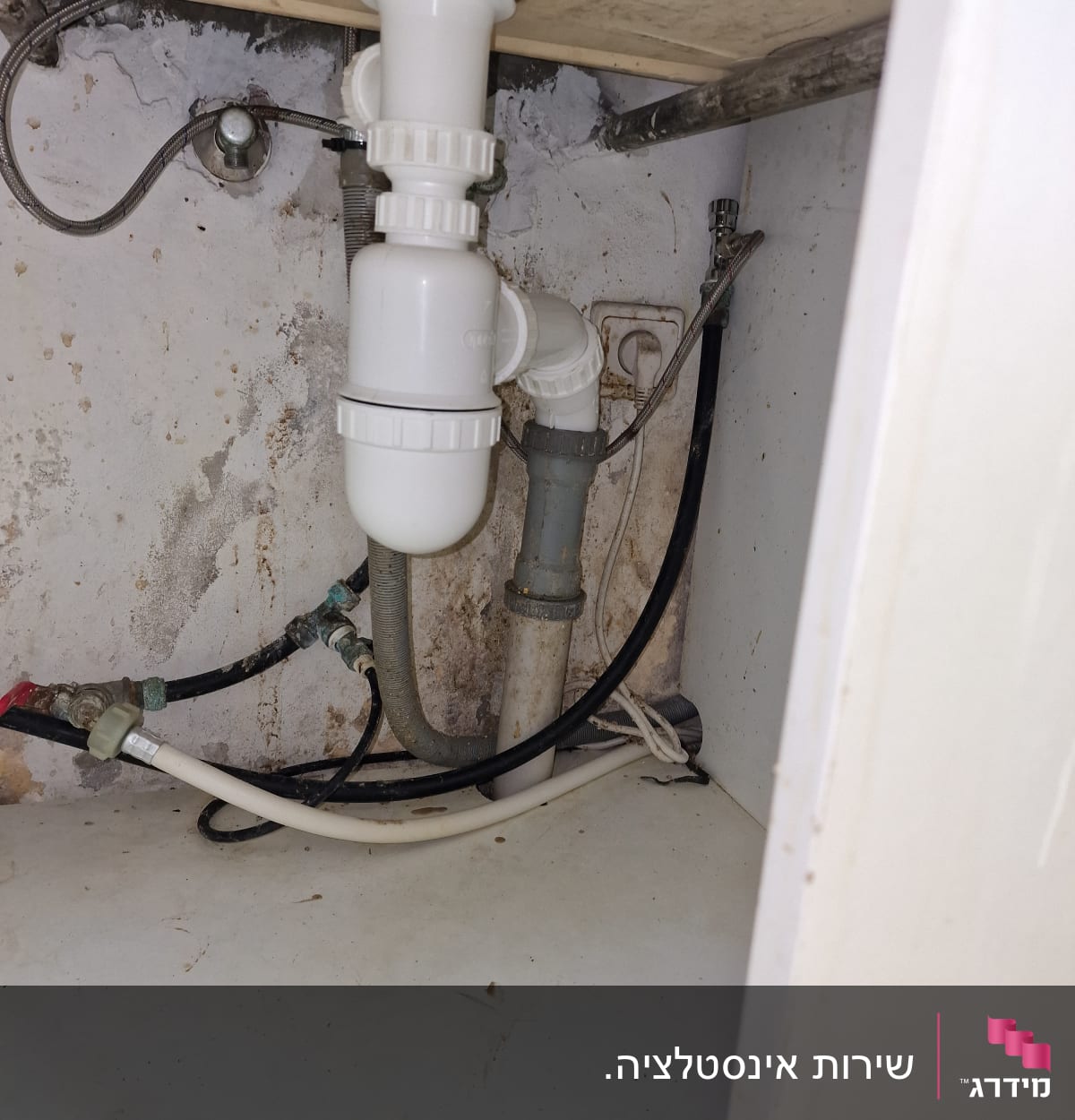 צנרת פלסטיק לבנה מתחת לכיור מטבח